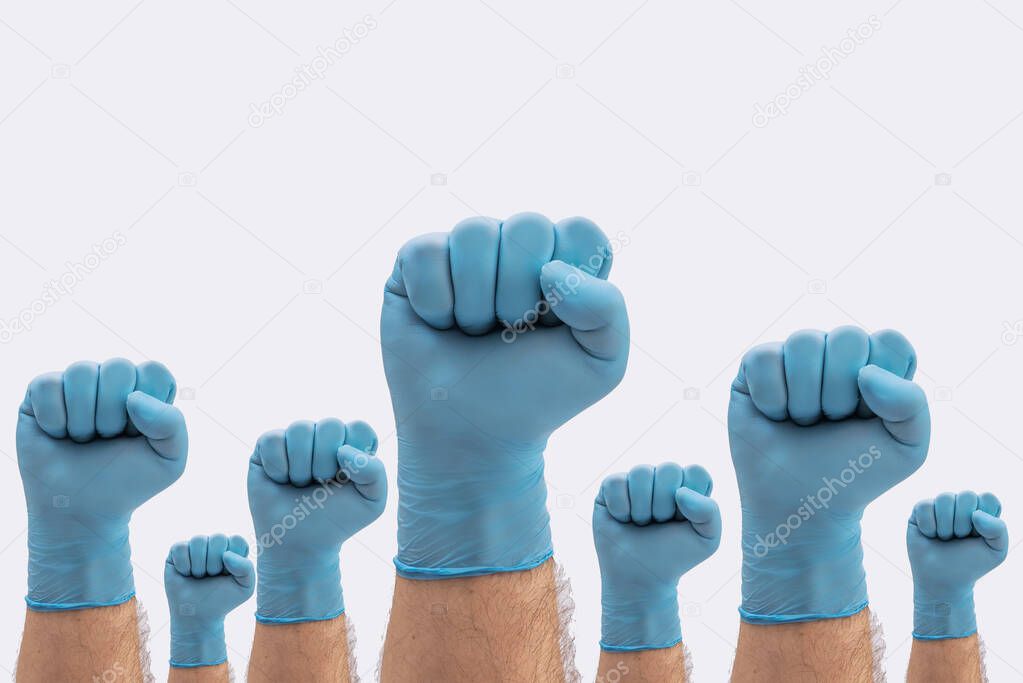 Fists Hands in medical blue latex protective gloves as a sign of resistance to pandemic - on white background stop disease sign