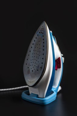 Siyah arka planda iyi kullanılmış Buhar Ütüsü. Elektronik ütü.