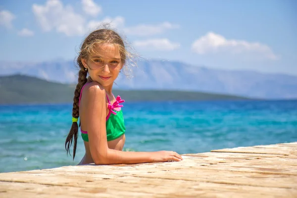 Menina no cais de madeira no mar — Fotografia de Stock