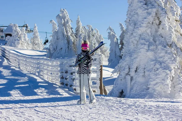 Flicka med skidor på berget — Stockfoto