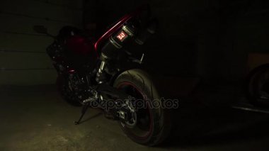 Genç erkek motorcu silueti bir motosiklet garaj alır..