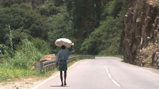 Człowiek z torbą na głowie chodzenie w dół drogi — Wideo stockowe