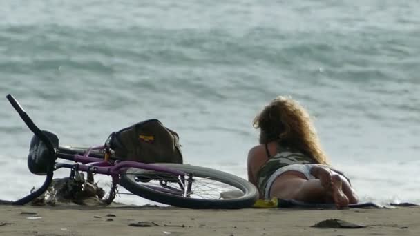 女人与自行车躺在海滩上 — 图库视频影像