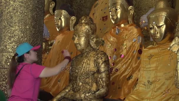 Worshiper paste gold buddha — Stock Video