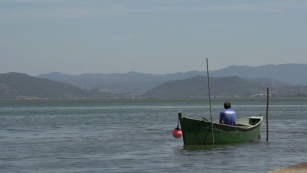 Лагуна, рыбак на лодке — стоковое видео
