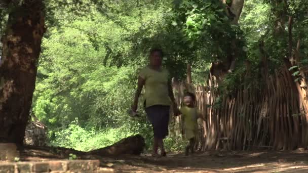 Femme et enfant marchant dans le village — Video
