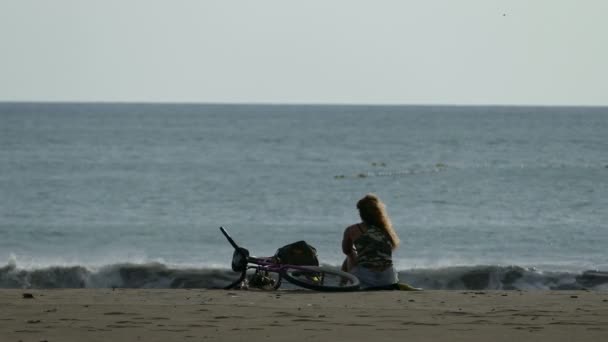 Mujer con bicicleta puesta en la playa — Vídeos de Stock