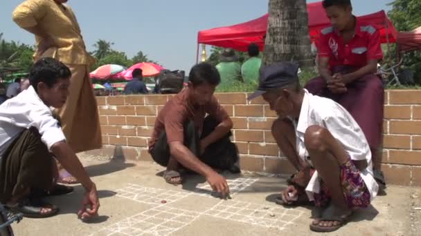 Yangon, mannen spelen dobbelstenen spel op de grond — Stockvideo