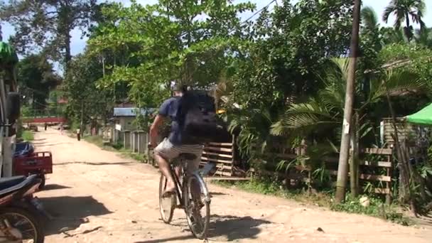 Туристы ездят на велосипеде по деревне — стоковое видео