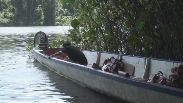 苏里南 Palumeu 男子从他的船上删除水的镜头 — 图库视频影像