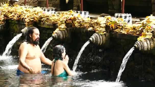 不明身份的巴厘岛家庭来到印尼巴厘岛 Tirta Empul 的圣泉水神庙 祈祷和净化他们的灵魂 — 图库视频影像