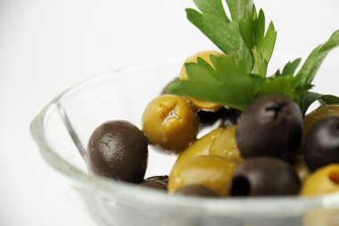 Zeytin. Cam bir kabın içinde maydanozlu zeytin.