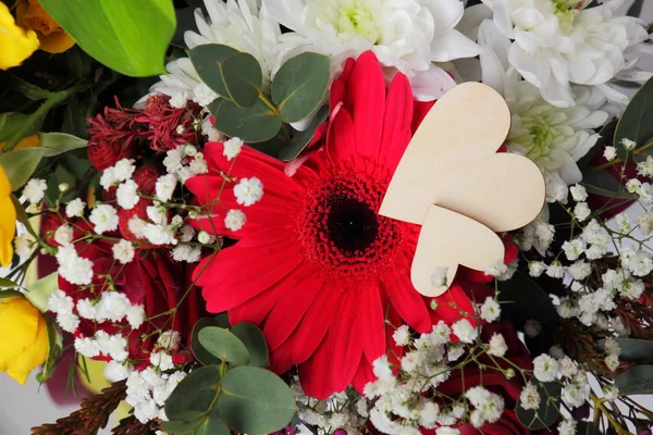 情人节的花朵布置 用一束玫瑰 百合花和其它花朵装饰着木制的心 — 图库照片
