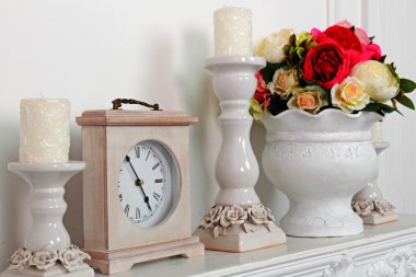 Noel süslemeli yeni yıl kompozisyonu - şöminede mumlar ve klasik saatli şamdanlar. Beyaz arkaplanda kompozisyon.