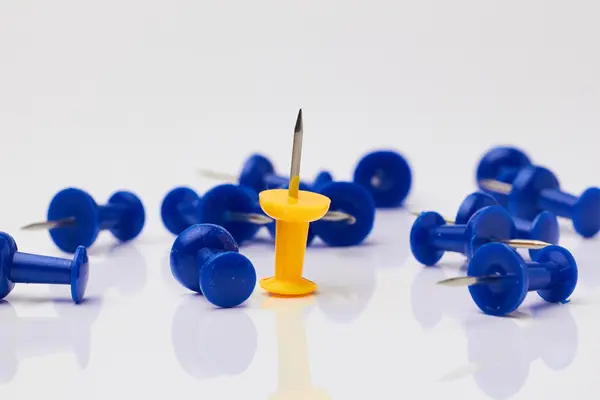 Beyaz zemin üzerinde mavi ve sarı raptiye.