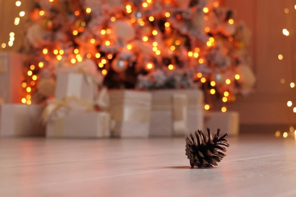 Koni ladin ve çelenk. / Koni ladin Noel ışığının zemininde yatıyor..