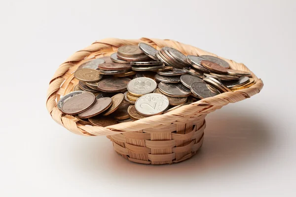 Wicker hat with coins. Royalty Free Stock Photos