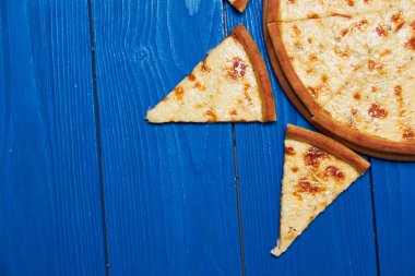 Tahta üzerinde üç peynirli pizza..