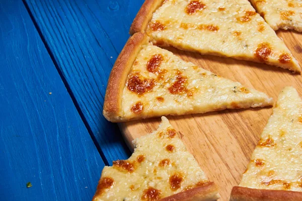 Tahta üzerinde üç peynirli pizza..