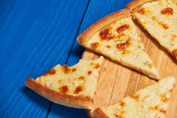 Tahta üzerinde üç peynirli pizza..