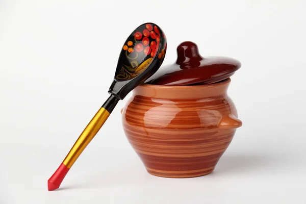 Seramik kap ve kaşık. Beyaz arka planda kapağı olan kaşık ve seramik kap.