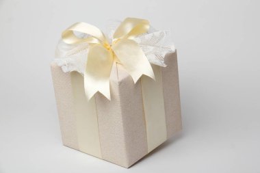 - Güzel paketlenmiş hediye. - İçinde bej kağıt, altın kurdele ve dantel olan güzel bir hediye kutusu..