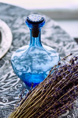 Boş mavi şişe ve bir demet kuru lavanta.