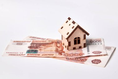 Russian rubles banknotes under house./Currency, For Sale, House, Mortgage Document, Moving House clipart