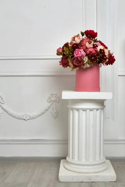 Big bouquet of flowers on the column./A large bouquet of flowers on a column in the lobby.