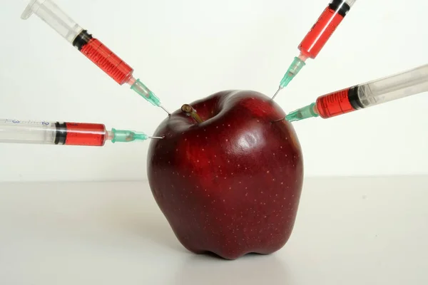 リンゴとそれの注射器 遺伝子組み換え作物の果実 遺伝子組み換え食品の成分 — ストック写真