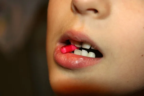 Kid taking pills. Kid taking antibiotics. Child using medical pills.