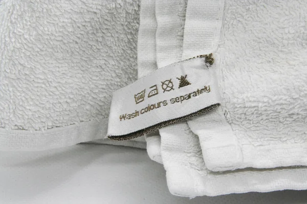 Waschanleitung Kleideretikett Auf Weißer Baumwolle Als Hintergrund — Stockfoto