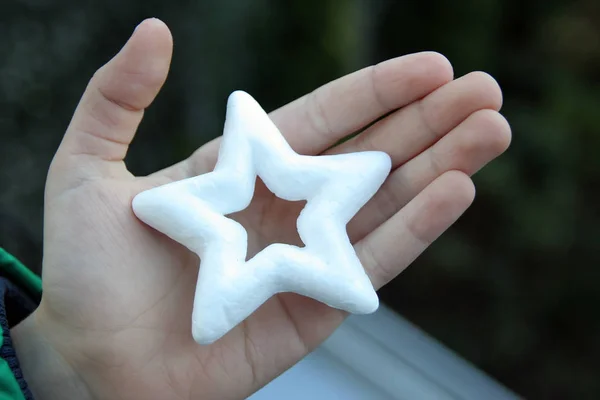 Kid with star in his hand. Decoration star in kids hand. Star holiday decoration.