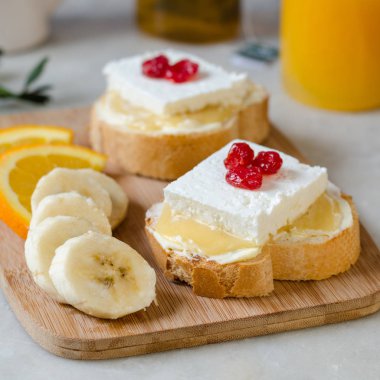 Tereyağı, bal ve yumuşak peynir ile bir sandviç. Sağlıklı ve lezzetli bir kahvaltı kavramı.