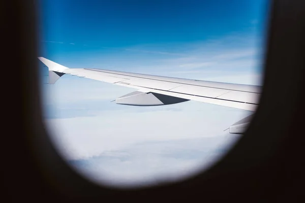 Ventana de avión con cielo azul y nubes — Foto de Stock