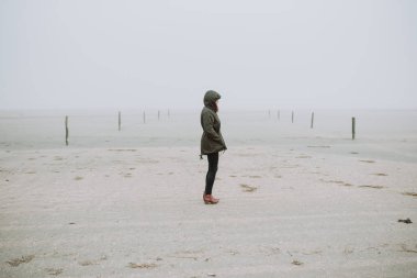 Boş sahilde duran kadın