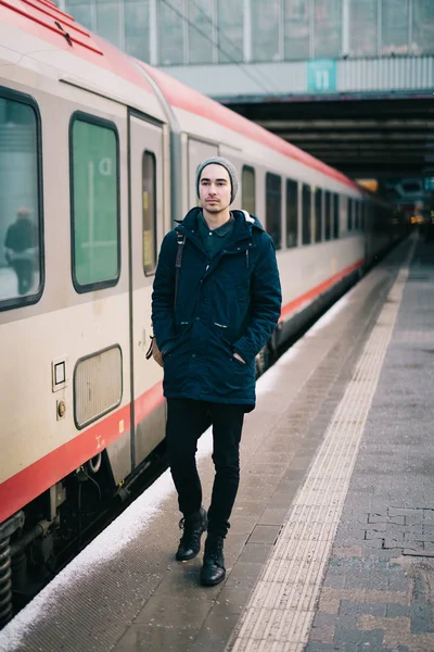 Młody człowiek przechodzący obok pociągu — Zdjęcie stockowe