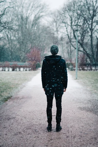 雪の中公園に立っている若い男 — ストック写真
