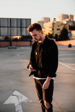 Genç adam cep telefonu kullanıyor.