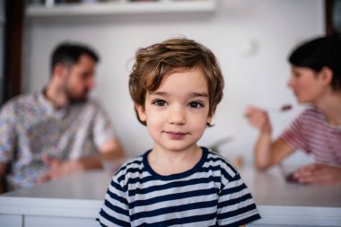 Küçük çocuk evinde. Ailesi onun arkasında..