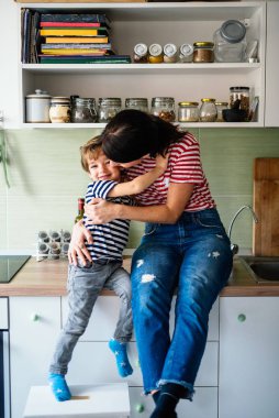 Küçük çocuk ve annesi mutfakta.
