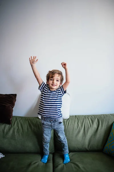 Kanepede Kollarını Kaldırmış Küçük Bir Çocuk — Stok fotoğraf