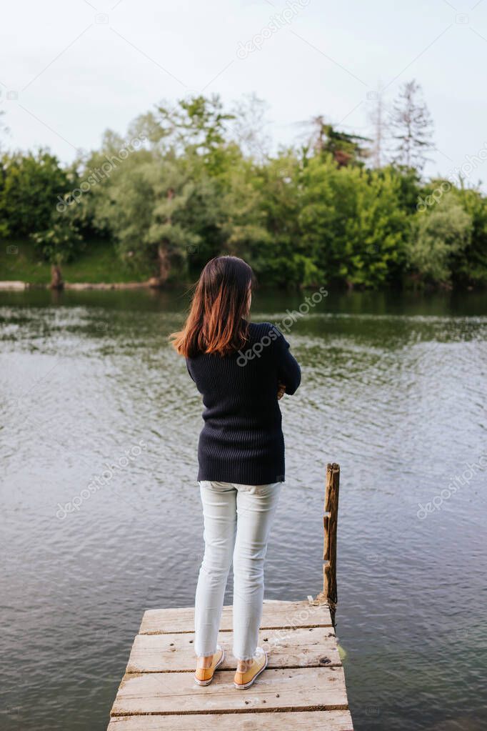 Woman standing on the river pier 