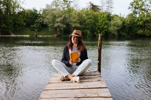 Nehir Rıhtımında Kitap Okuyan Genç Bir Kadın — Stok fotoğraf