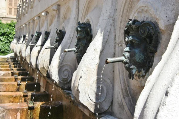 Historical fountain with bronze faces in Ancona city centre, Italy