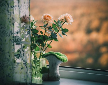 pencerede çiçekli vazo