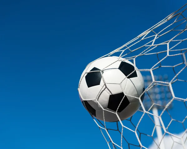 Fotboll i målet netto med blå himmel — Stockfoto