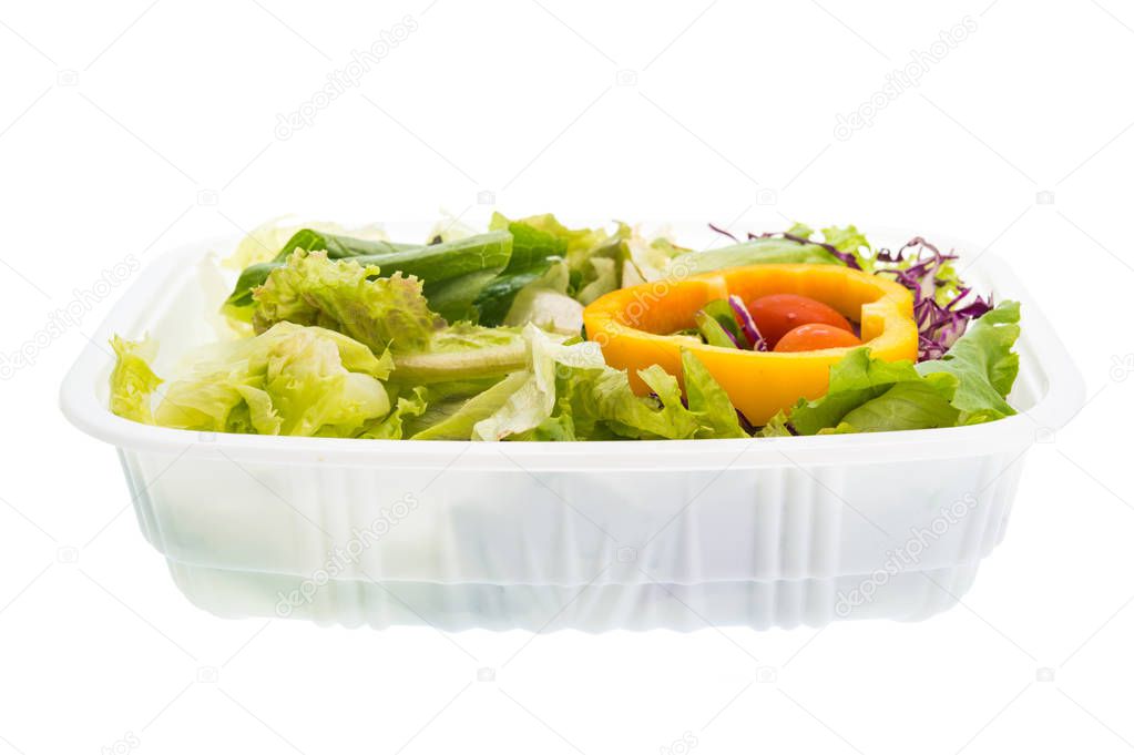 Salad in plastic container isolated on white background