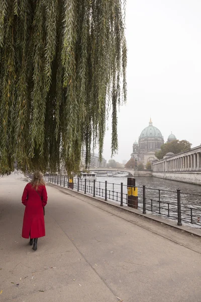 Donna in cappotto rosso sotto il salice piangente vicino alla furia del fiume a berli — Foto Stock