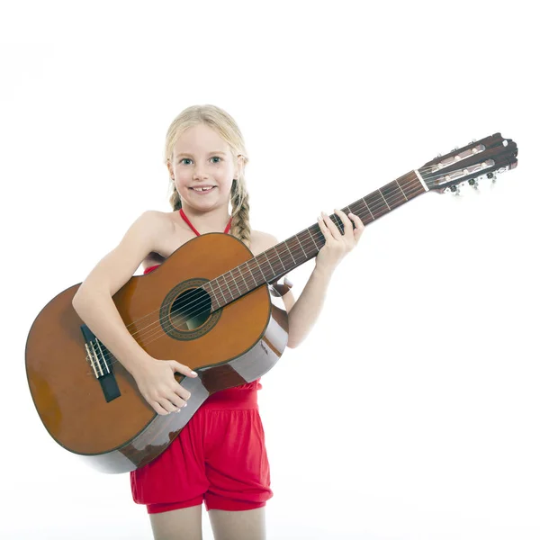 Joven feliz chica en rojo se levanta con la guitarra —  Fotos de Stock